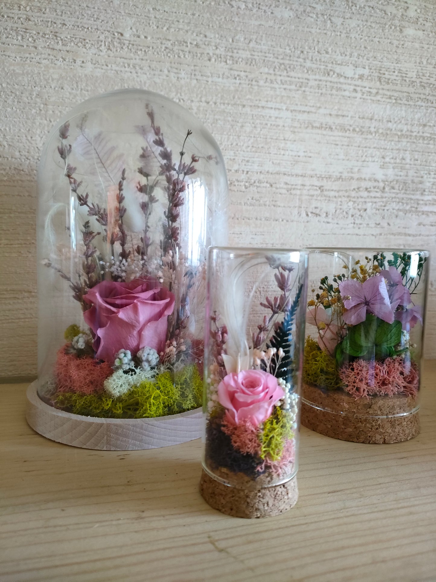 Campana in vetro con rosa stabilizzata al centro, composizione floreale botanica elegante.