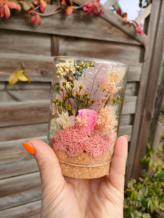 Campana in vetro bomboniera con rosa stabilizzata al centro, composizione floreale botanica elegante.